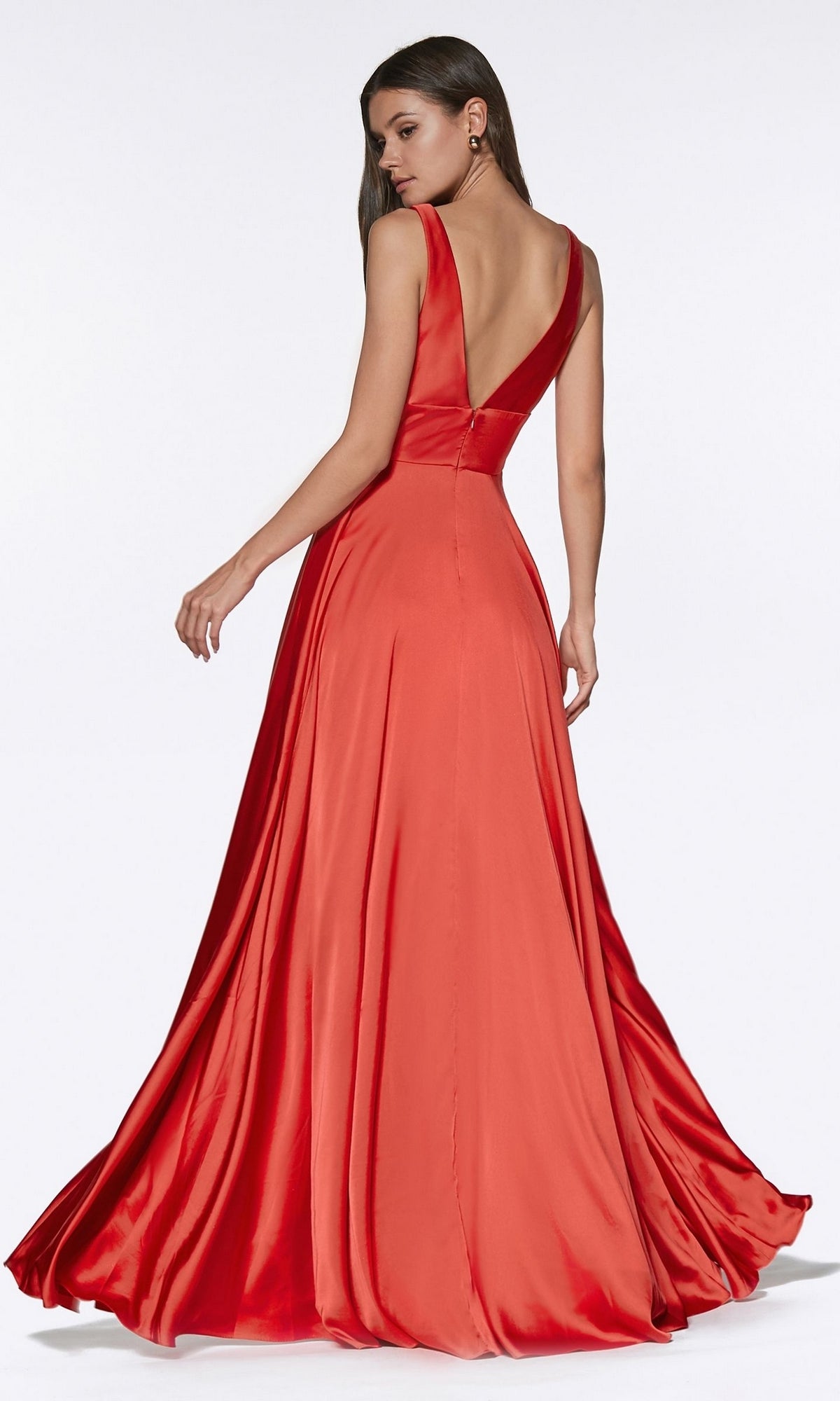 A woman in an Empire-Waist Simple Satin Long A-Line Prom Dress stands against a plain white background, backless and sleeveless, facing away while looking over her shoulder.